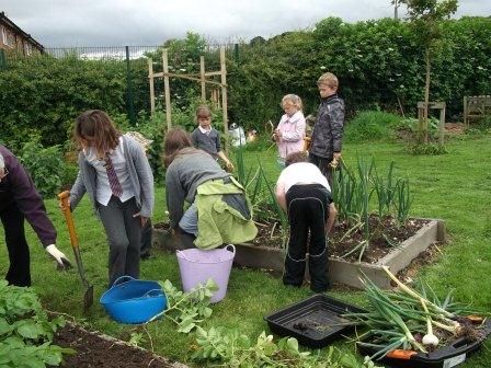 School children help tend a garden.