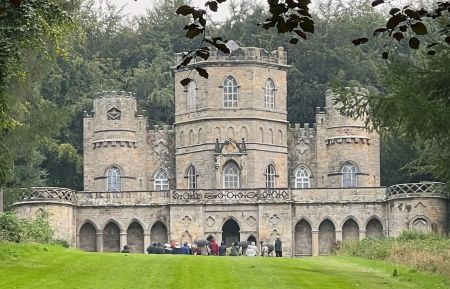 Stone building with tower and Gothick arches with lawn in front