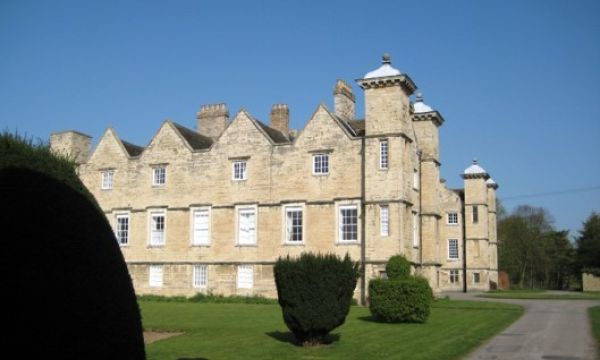 Ledston Hall view of house and yew topiary on grassed lawn to the side