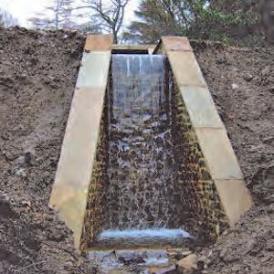 An engineered waterfall with stone sides.