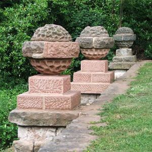 Stone pillars stand at the edge of a landscaped garden area.