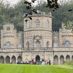 Stone building with tower and Gothick arches with lawn in front